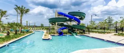 a water slide in a pool at a resort at Brand New Storey Lake 8BR Villa with Lake View in Kissimmee