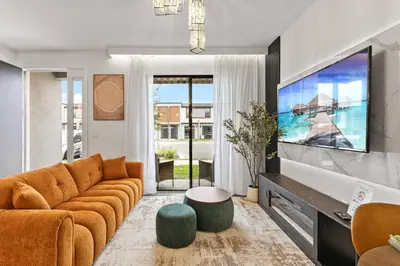 a living room with a couch and a large tv at 3251 The Hub escape with flex space in Kissimmee