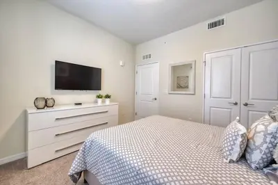 a bedroom with a bed and a flat screen tv at 3 Bed Condo Close to Disney at Storey Lake in Kissimmee
