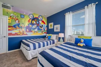 two beds in a room with a mural on the wall at 3 Bed Condo Close to Disney at Storey Lake in Kissimmee