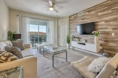 a living room with a couch and a tv at 3 Bed Condo Close to Disney at Storey Lake in Kissimmee