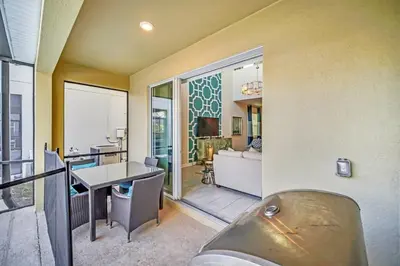 a room with a balcony with a desk and a living room at Dazzling 5BR Villa in Storey Lake with Pool & Spa 1528 in Kissimmee