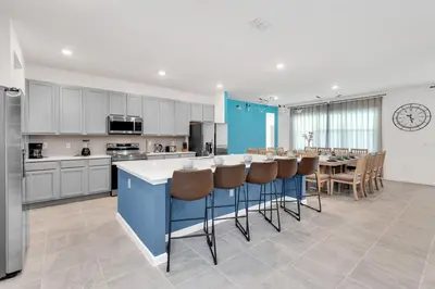 a kitchen with a bar and a table with stools at DeepSea World 15 Suites Sleep 30 Oversize Pool Spa in Kissimmee