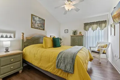 a bedroom with a yellow bed with a ceiling fan at CLD4676 in Kissimmee