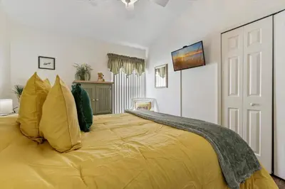 a bedroom with a large bed with yellow pillows at CLD4676 in Kissimmee
