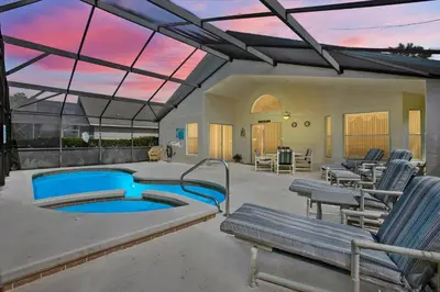 a patio with a pool and chairs and a table at CLD4676 in Kissimmee