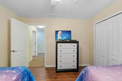 a bedroom with two beds and a dresser with a picture on it at BCH3071 in Kissimmee