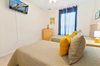 a bedroom with two beds with yellow pillows at CCL8536 in Kissimmee