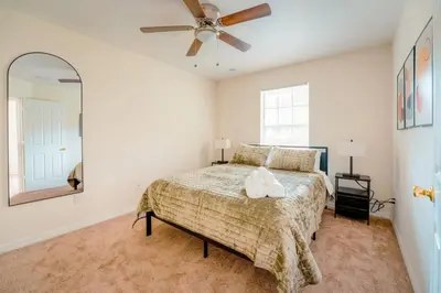 a bedroom with a bed and a ceiling fan at Full House HotTub Mins to UCF in Bithlo