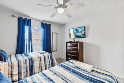 a bedroom with two beds and a ceiling fan at Wonderful 4 bed Family Home with Private Pool in Kissimmee