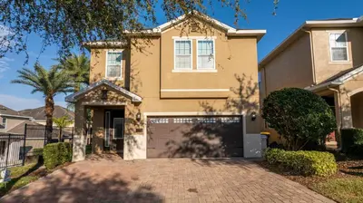 a house with a driveway in front of it at Classic 8bd house - Encore Reunion Close to Disney in Orlando