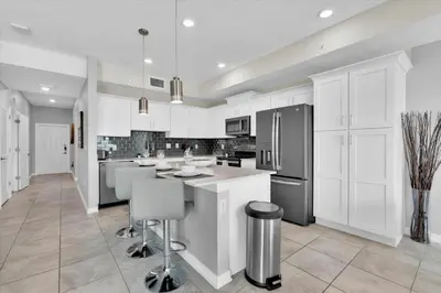 a kitchen with white cabinets and stainless steel appliances at PXC3151-306 in Kissimmee