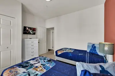 a bedroom with two beds and a dresser at GDL3206 in Kissimmee