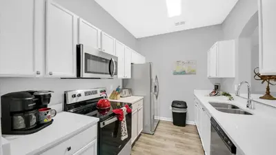a kitchen with white cabinets and a stove top oven at ALM2788-301 in Orlando