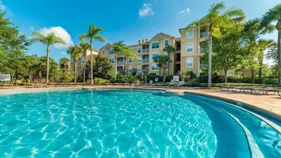 a swimming pool with palm trees and condos at ALM2785-304 in Orlando