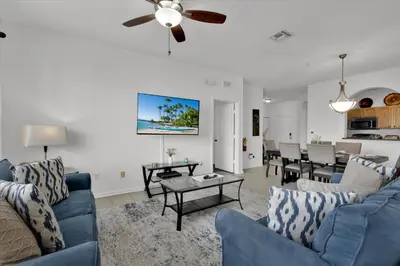 a living room with blue couches and a dining room at ALM2785-304 in Orlando