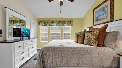 a bedroom with a bed with a dresser and a television at SKC7653 in Orlando