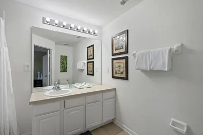 a white bathroom with a sink and a mirror at MSW2563 in Orlando