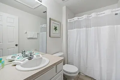 a white bathroom with a sink and a toilet at MSW2563 in Orlando