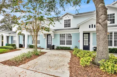 a white house with black windows and trees at SKC7644 in Orlando