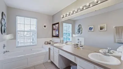 a white bathroom with two sinks and a tub and a bathtubermott at DB2644 Windsor Hills Resort 6 Bedroom in Orlando