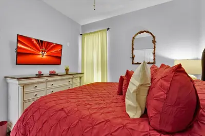 a bedroom with a red bed and a dresser at TT7752 Windsor Hills Resort 6br in Orlando