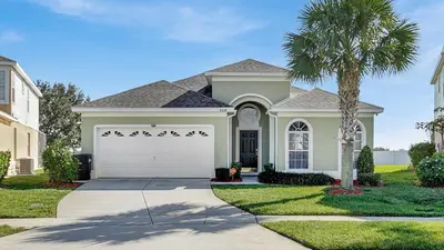 a house with a palm tree and a white garage at KP8034 Windsor Palms Resort 4 Bedroom Private Pool in Kissimmee