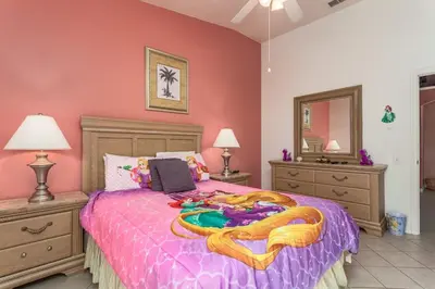 a bedroom with a large bed with a purple comforter at WP2217 Windsor Palms Resort 4 Bedroom Private Pool in Kissimmee