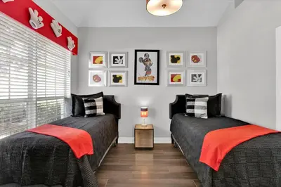 two beds in a bedroom with red and black at SP8131 Windsor Palms Resort 6 Bedroom in Kissimmee