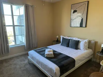 a bedroom with a bed and a large window at Cozy condo Just a few minutes from Disney in Kissimmee
