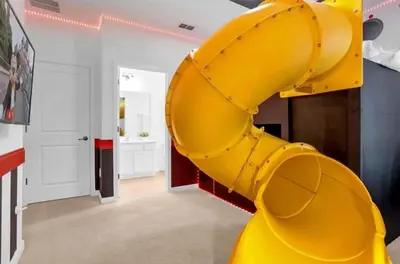 a yellow slide in a living room with a yellow at 2525 Shanti Amazing 15 Suites Mansion in Kissimmee