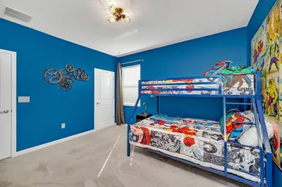 a bedroom with blue walls and a bunk bed at 2525 Shanti Amazing 15 Suites Mansion in Kissimmee