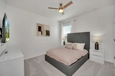 a bedroom with a bed and a ceiling fan at 2525 Shanti Amazing 15 Suites Mansion in Kissimmee