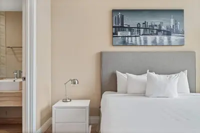 a bedroom with a bed and a bathroom with a sink at Minutes to Disney Chic Dream Villa with Stunning Patio and Resort Perks in Orlando