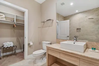 a bathroom with a white sink and a toilet at Minutes to Disney Chic Dream Villa with Stunning Patio and Resort Perks in Orlando