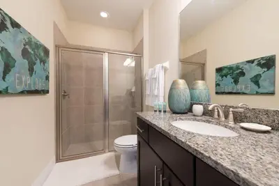 a bathroom with a shower and a sink and a toilet at Elegant 8BR Encore Resort Pool w Spa GameRoom Single Family in Orlando