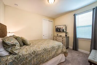 a bedroom with a bed and a dresser and a window at Elegant 8BR Encore Resort Pool w Spa GameRoom Single Family in Orlando