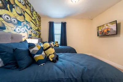 a bedroom with a blue bed and a painting on the wall at Elegant 8BR Encore Resort Pool w Spa GameRoom Single Family in Orlando