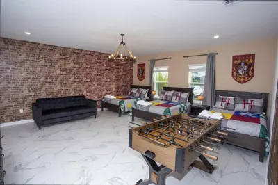 a living room with two beds and a couch at Epic Dream Home with Spa Game Room Themed Bedrooms 2887 Single Family in Kissimmee