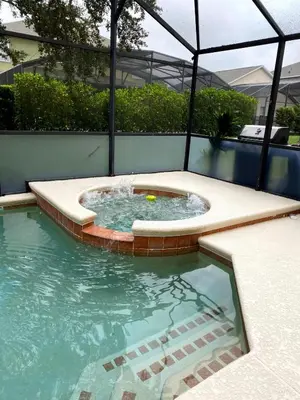 a pool with a hot tub in the middle at Vacation Villa Near Disney With Private Pool Spa in Kissimmee
