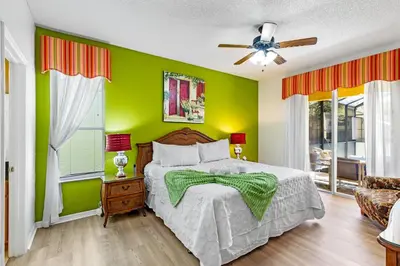 a green bedroom with a bed and a ceiling fan at Disney Doorstep 7 Bedroom Villa with SouthFacing Pool and Hot Tub in Kissimmee