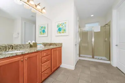 a bathroom with two sinks and a shower at Welcoming Home With Game Room And Private Pool With Water Park Access At Encore Resorts Reunion - 150Mn in Kissimmee