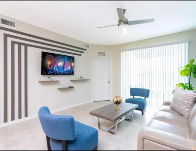 a living room with a couch and chairs and a tv at Amazing Townhome With Lake View At Storey Lake Resort in Kissimmee