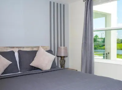 a bedroom with a bed and a window at Amazing Townhome With Lake View At Storey Lake Resort in Kissimmee