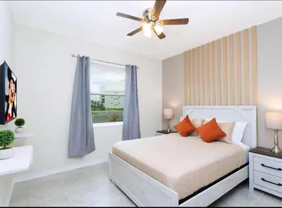 a bedroom with a bed and a ceiling fan at Amazing Townhome With Lake View At Storey Lake Resort in Kissimmee