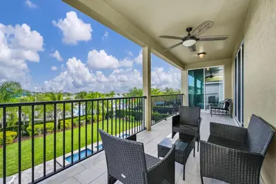 a balcony with chairs and a ceiling fan at Extravagant Home With Movie Theater, Private Pool And Waterpark & Resort Access At Encore Resort - 241Fl in Kissimmee