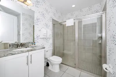 a white bathroom with a shower and a toilet at Magnificent Home With Private Pool, Theater & Game Room Near Disney With Waterpark & Resort Access At Encore Resort - 230Bu in Kissimmee