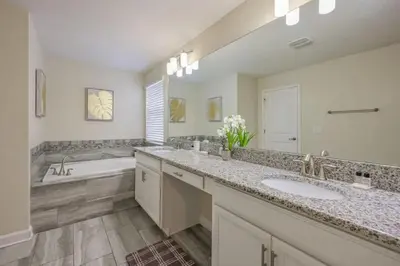 a bathroom with two sinks and a bath tub at Casa 5Q | Piscina Privativa & Vista para o Lago in Kissimmee