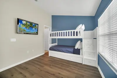 a bedroom with a white bunk bed and blue walls at Perfect Townhome Near Disney in Orlando