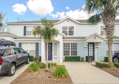 a white house with a car parked in front of it at Perfect Townhome Near Disney in Orlando